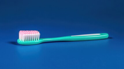 Teal toothbrush with pink bristles on blue background.