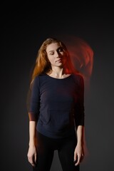 Fototapeta premium Dancer in motion exuding beauty with flowing hair against a dark backdrop