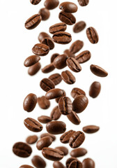 Obraz premium Roasted coffee beans are falling on a white background, creating a sense of motion and energy.