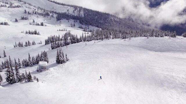 Skier overlooking breathtaking mountain vista, aerial footage, ski mountain, sunny day, winter, ski hill, Whistler BC. 5.4K 24FPS