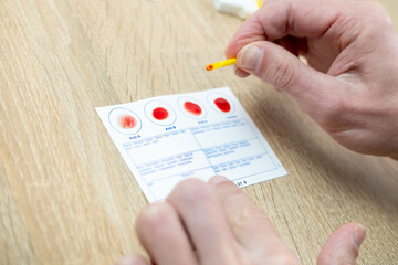Blood typing test being performed, showing results on card, focusing on health and diagnostics,...