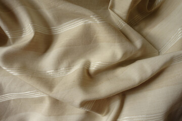 Wrinkled light beige striped cotton and polyester fabric