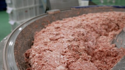 Industrial mincing machine processing ground meat in food factory