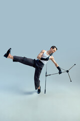 Artistic chaos. Performer balancing on one foot while gripping microphone stand in expressive...