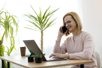Woman working from home while on a phone call