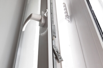 Close-up of a double-glazed balcony frame with a latch and fastening for safe ventilation. Single-sided window handle