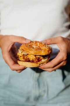 Smashed cheeseburger with sesame bun outdoors in summer