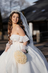 A woman in a wedding dress is holding a bouquet of flowers. She is smiling and she is happy