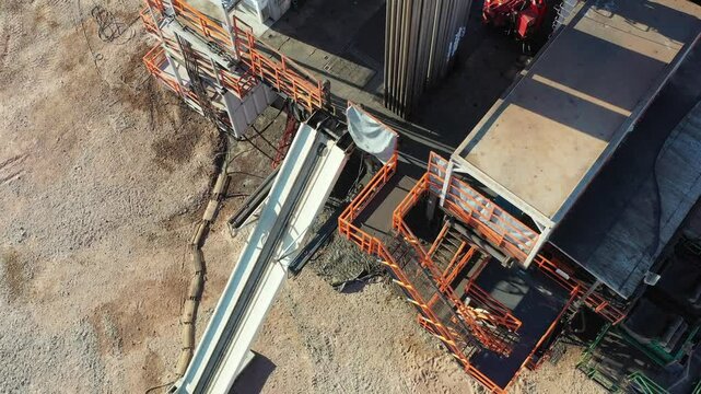 People in orange overalls walk inside a drilling rig in Vaca Muerta Neuqu&eacute;n Argentina