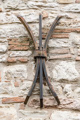 A metal object with three legs is attached to a wall in Gubbio Italy Umbria