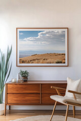 Modern living room featuring a framed landscape with vast fields, a blue sky, and decorative plants, creating a serene atmosphere during the day