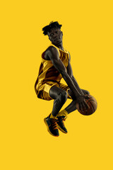 Dynamic composition. Young African-American man, basketball player mid-air, intense jump creating...
