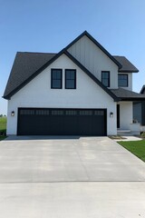 Fototapeta premium This contemporary house features a stylish design and a generous driveway, set in a picturesque suburban neighborhood beneath a beautiful, clear blue sky