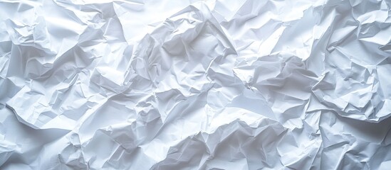 Crumpled white paper texture with irregular folds and creases emphasizing contrast and depth in the center against a light background
