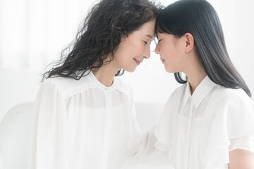 祖母と孫が微笑みながら目を閉じて額をつけている。