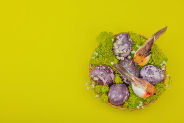 Marble Easter eggs, wooden basket, moss, gypsophila flowers. Festive concept, greeting card