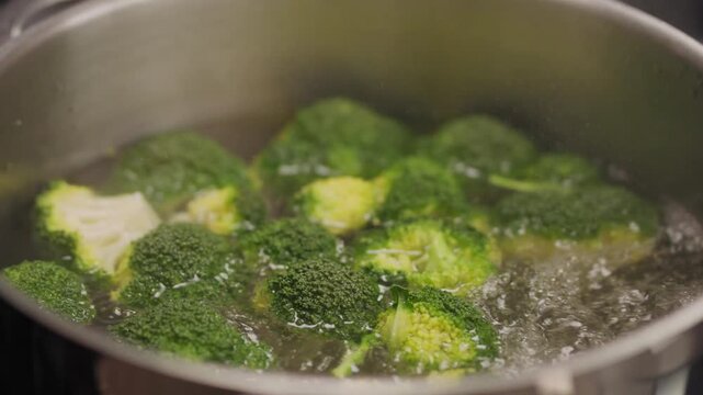 Brokkoli wird in einem Aluminium Topf mit wasser durch gekocht um ein gesundes veganes essen zu bereiten