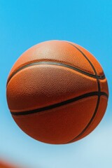 Obraz premium Basketball soaring through clear blue sky captures dynamic energ