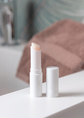  Opened white blank lip balm stick on basin in tropical bathroom close up, cosmetic mockup
