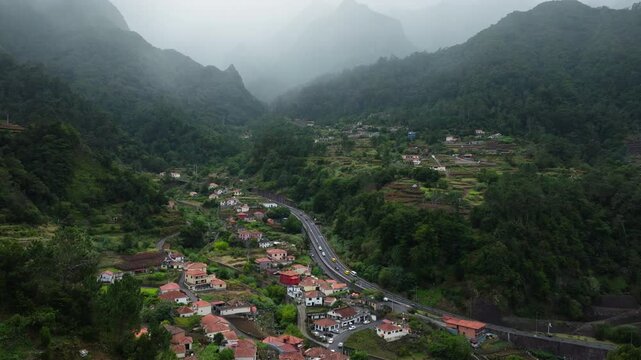 Aerial Drone showing cars driving up to a tunnel entering mountains, Madeira island, Portugal