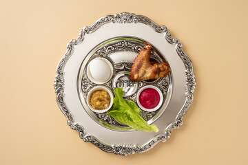 Passover Seder plate featuring symbolic items including a shank bone, lettuce, egg, and condiments. Perfect representation of the Jewish holiday Passover and its traditional symbolism