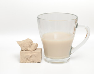 Zaczyn drożdżowy rozpuszczony w mleku w kubki na białym tle, kuchnia domowa, domowe wypieki, ciasto drożdżowe 