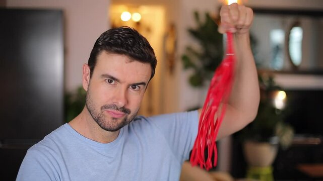 Comedian playing with a small leather whip 