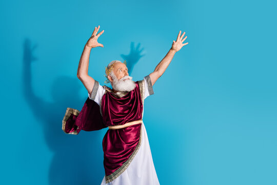 Photo of attractive old man cast spell magic dressed greek god emperor actor costume isolated on blue color background