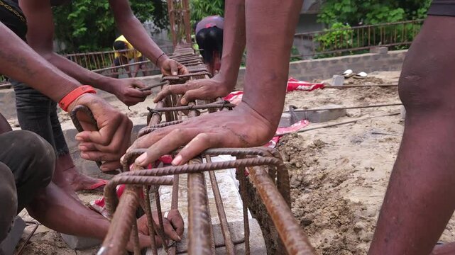Construction workers using reinforced tmt steel bar with ease at the construction site, Reinforced bar (rebar). TMT steel rods tied together forming the core of concrete