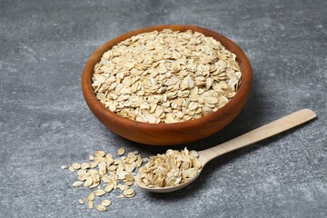 Composition with oatmeal flakes on gray background. Cooking breakfast