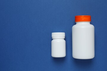 White bottles on blue background, top view