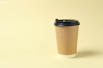 Paper cup with plastic lid on light background. Coffee to go