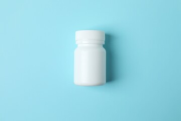 White bottle on blue background, top view