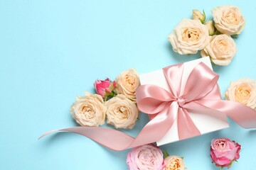 Beautiful composition with peony roses and gift box on color background