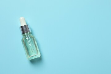 Skin care with cosmetic facial serum. Glass bottle with a pipette on a blue background. Dry skin care product. Essential oil for moisturizing the skin of the body. Brand layout