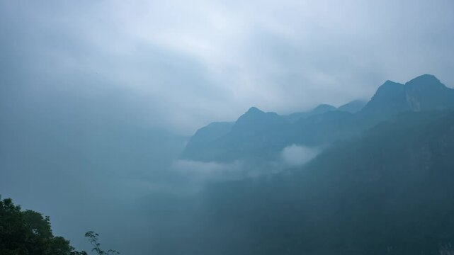 Time-lapse footage of white clouds constantly drifting from the top of the mountain
