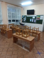 Empty classroom with wooden desks and chairs.
