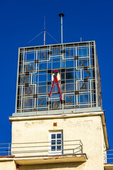 An old clock on a high tower against the blue sky, the clock face on the town hall tower Czestochowa