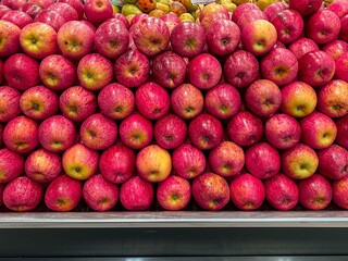 Red apples on display on supermarket shelf