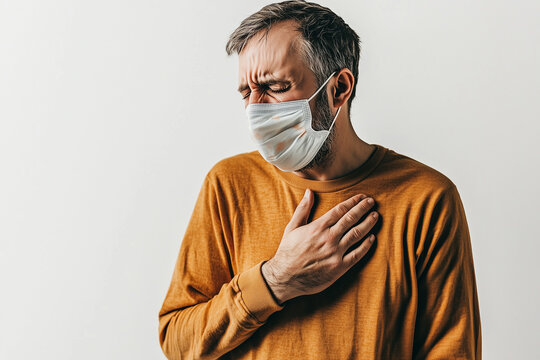 World Tuberculosis Day, Man in Mustard Yellow Sweater Wearing Face Mask Coughing and Holding Chest in Pain