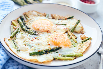 Fried eggs with asparagus and grated cheese. Breakfast concept.