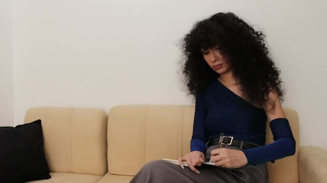 Video of a Latina woman writing and taking notes