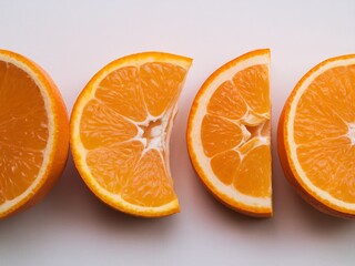 Vibrant orange slices arranged in a row against a light background, showcasing their juicy texture.