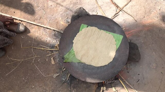 Overhead view of fermented banana leaves bread cooked on make shift firewood stove in traditional village of Dorze in Ethiopia, rural Africa
