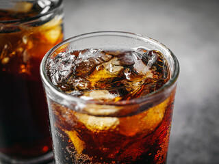 Cola soft drink with ice cubes, Close up of soda fizzy drink in Cold glass on gray background