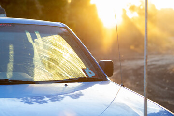 detail of ute with P plate in evening light and sun flare