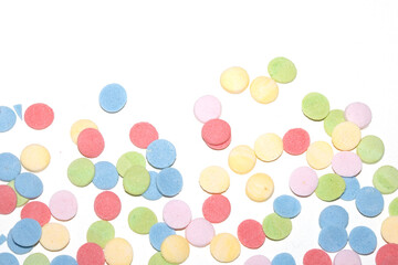 Close up of sugar paper confetti circle spots and colour dots on white background