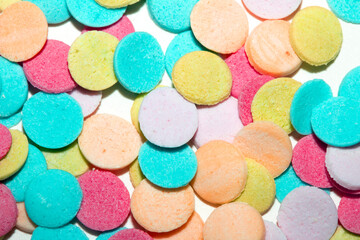 Close up of sugar paper confetti circle spots and colour dots on white background