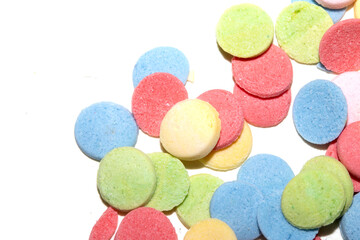 Close up of sugar paper confetti circle spots and colour dots on white background