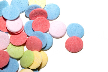 Close up of sugar paper confetti circle spots and colour dots on white background